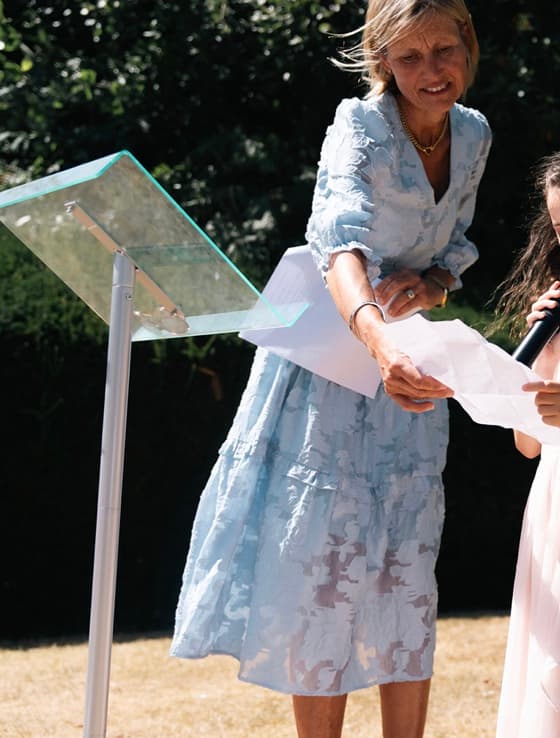 Jane handing a reading to a guest at an outdoor ceremony